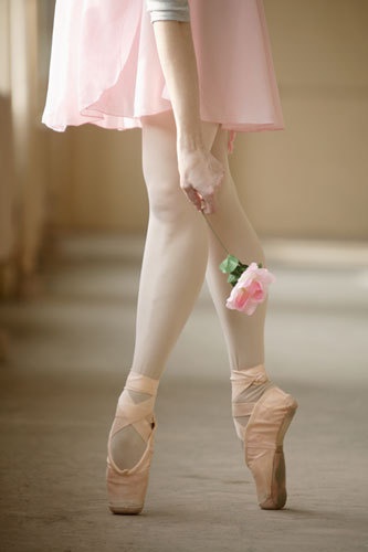 Балерина (без лица) с розовой розой в руке