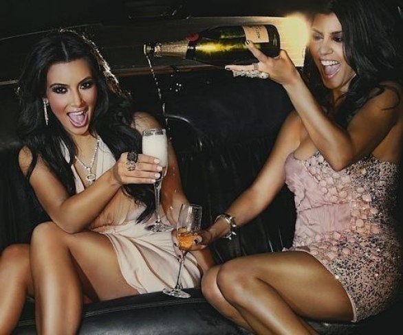веселые подружки пьют шампанское в машине