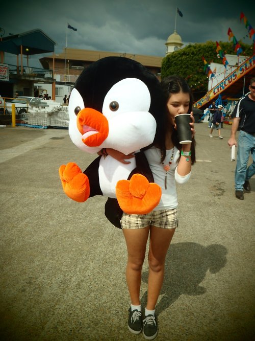 девушка с большим пингвином игрушкой в руках