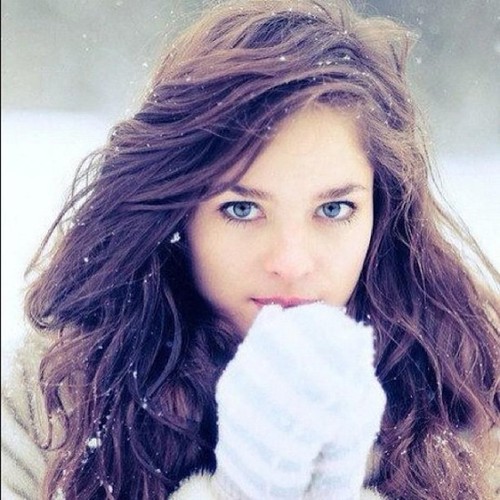 Красивая девушка в белых варежках зимой
