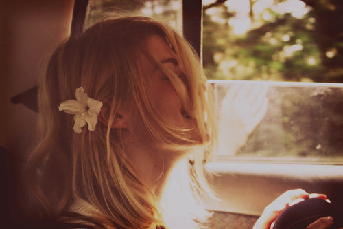 Смеющаяся в машине девушка с цветком в волосах
