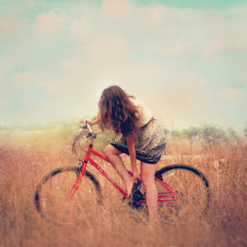 девушка а красным велосипедом в поле