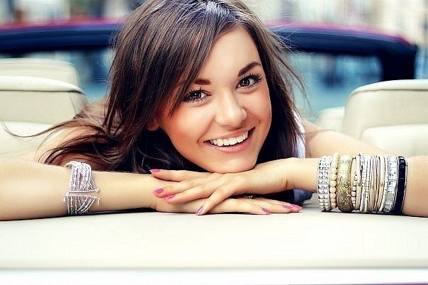 улыбающаяся красивая девушка с браслетами на руках