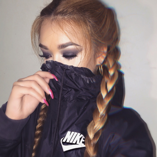 Девушка с косами, застёгивающая куртку Nike
