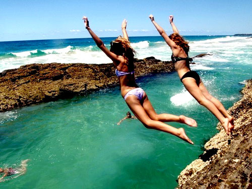 Две девушки,прыгающие с выступа в море