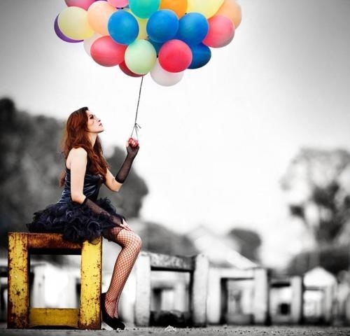 Девушка в чулках в сеточку держит цветные шарики