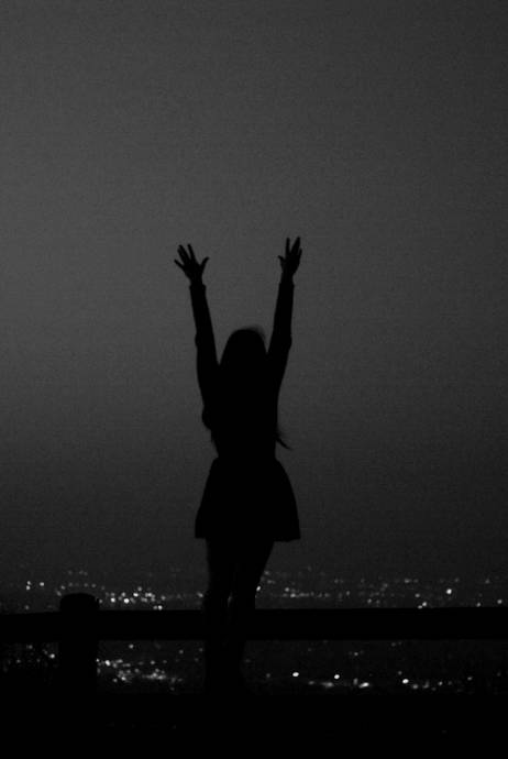 Силуэт девушки на крыше ночного города