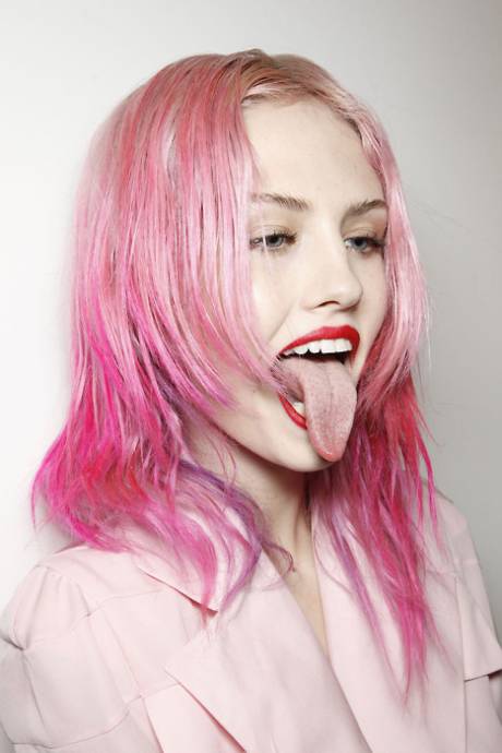 Девушка с розовыми волосами высунула язык