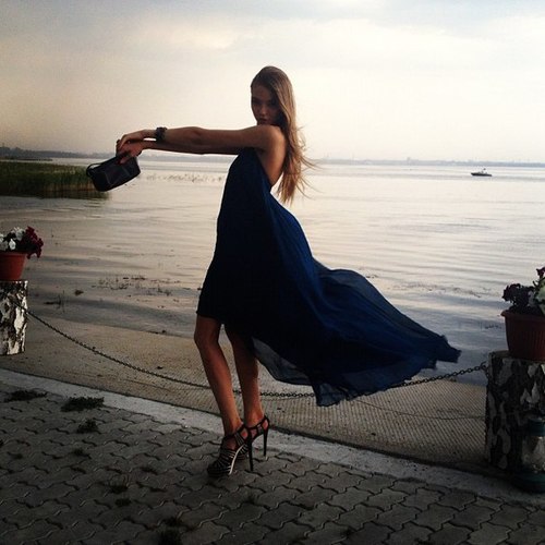 Девушка в синем развевающемся платье у моря
