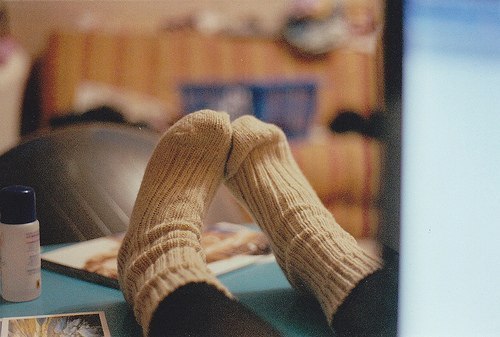 ножки девушки в теплых носочках на кровати