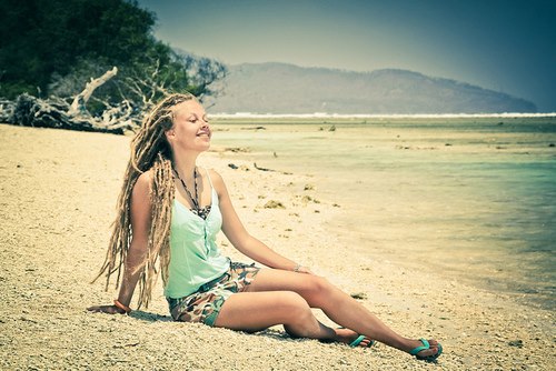 Красивая улыбающаяся девушка с дредами у моря