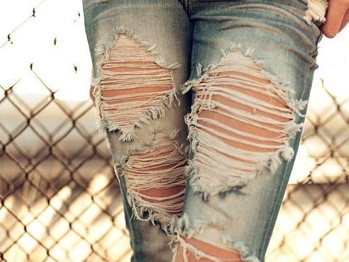 Ноги девушки в рваных джинсах
