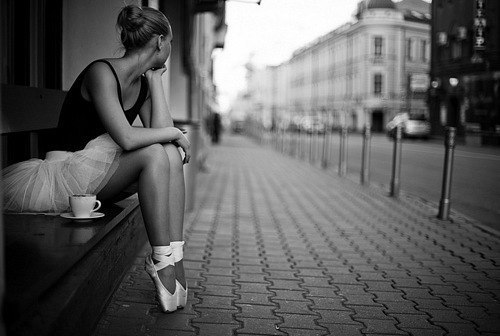 балерина сидит в пуантах на улице и чашечка чая