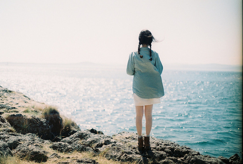 Девушка с косичками смотрит на море