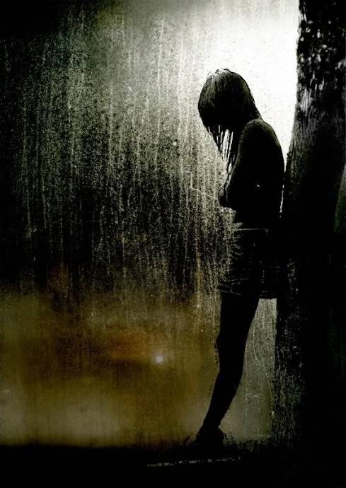 Одинокая девушка у дерева и дождь