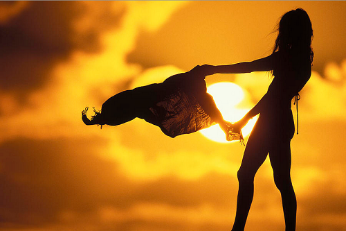 Силуэт девушки с шарфом на фоне заката солнца