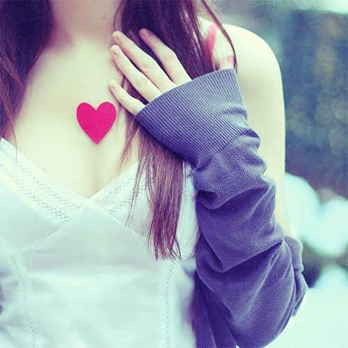 Девушка с красным бумажным сердечком на груди