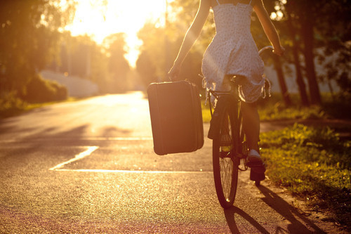 Девушка с чемоданом на велосипеде