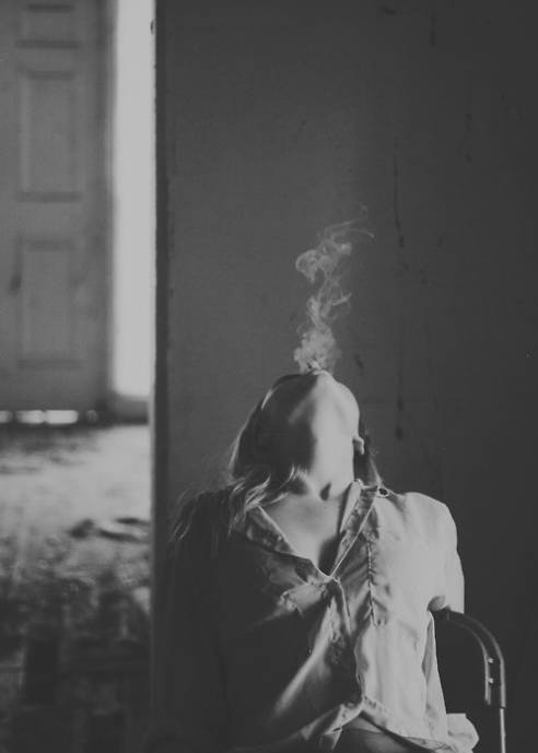 Выпускающая вверх дым сигареты, девушка