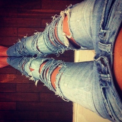 Ноги девушки в рваных джинсах