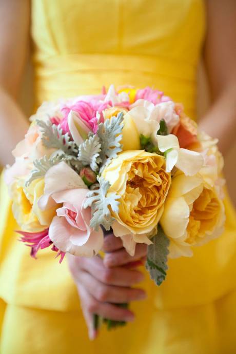 В желтом платье держит букет красивых ярких цветов