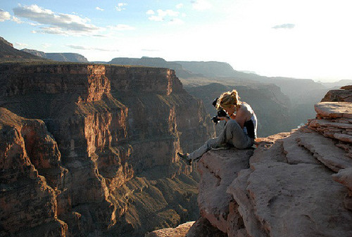 Девушка фотограф на краю скалы