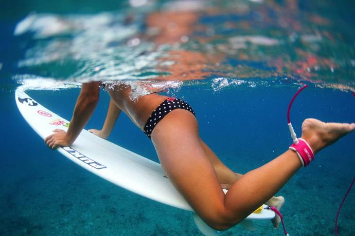 Девушка на сёрфинговой доске в купальнике в гороше