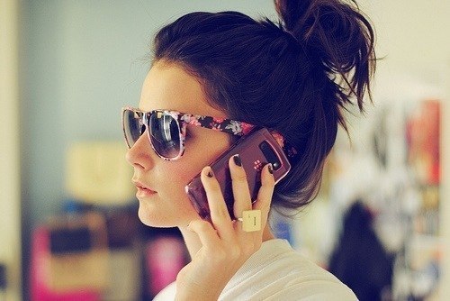 девушка в солнечных очках с мобильником