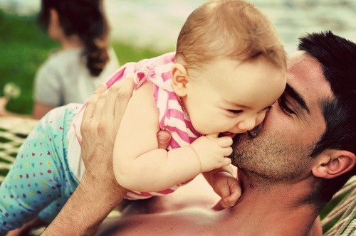 папа целует смеющуюся дочку