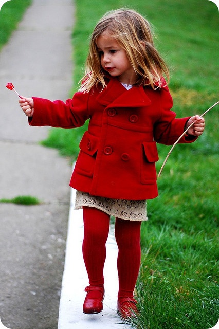 Девочка в красном пальто, колготках и туфлях