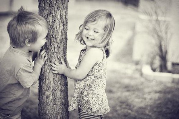 девочка прячется за деревом от мальчика