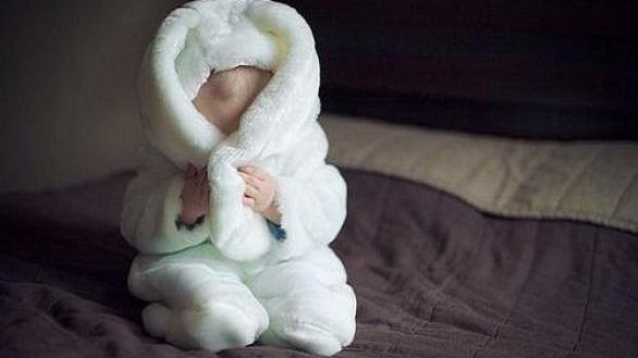 малыш в костюме зайчика прячет лицо в ушах