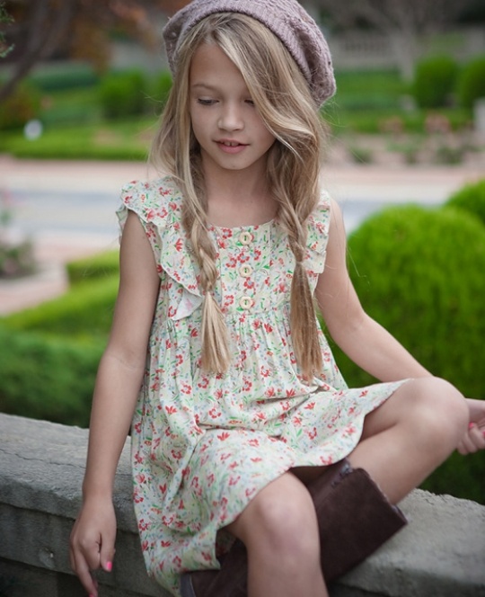 Девочка с русыми косами в цветастом платье