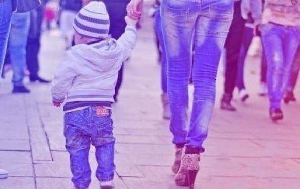 мама в джинсах держит за руку малыша в джинсах