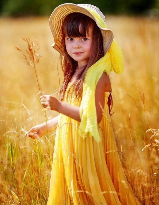 Девочка в жёлтом платье и шляпе в поле