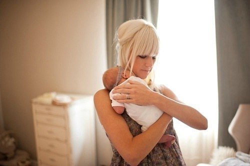 молодая мама держит на руках новорожденного малыша