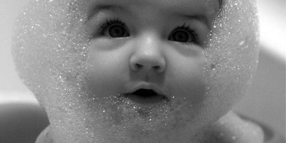 малыш купается в ванной в пене