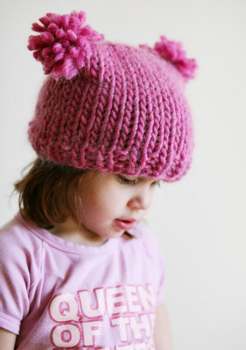 Девочка в вязаной розовой шапочке и кисточками