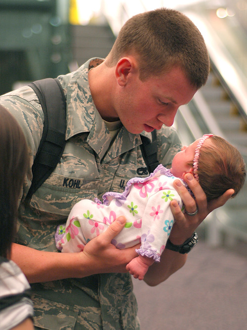 Солдат держит на руках новорожденную дочь