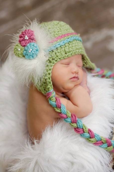 Спящая девочка в яркой вязаной шапке с косичками