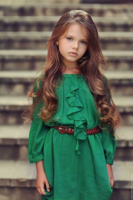 Красивая длинноволосая девочка в зеленом платье