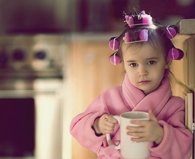 Девочка в бигудях и халате с чашкой чая в руках
