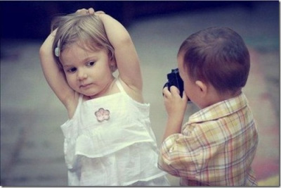 Мальчик фотографирует девочку