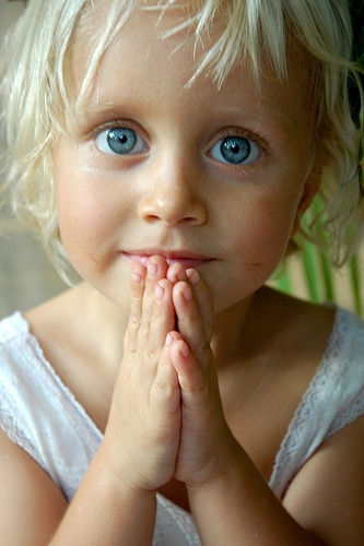 Девочка со сложенными ладонями как при молитве