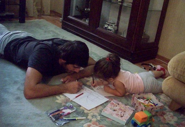папа с дочкой рисуют на полу лежа