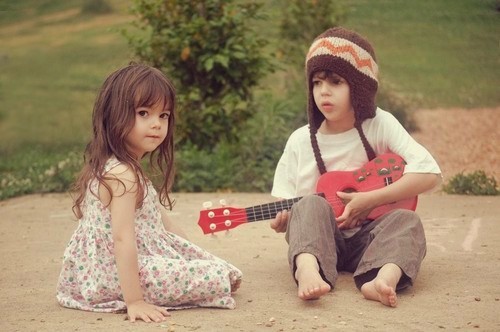 Мальчик играет для девочки на гитаре
