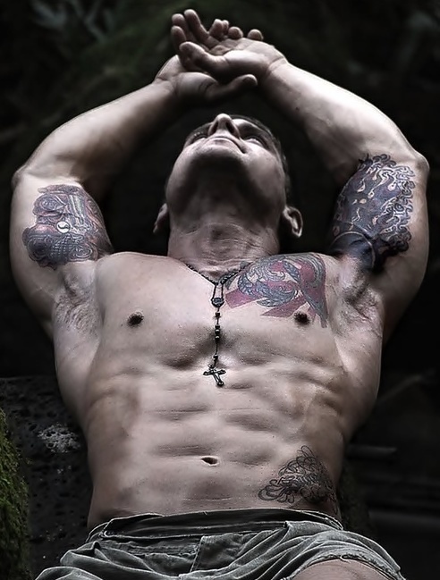 Мускулистый парень с татуировками на руках