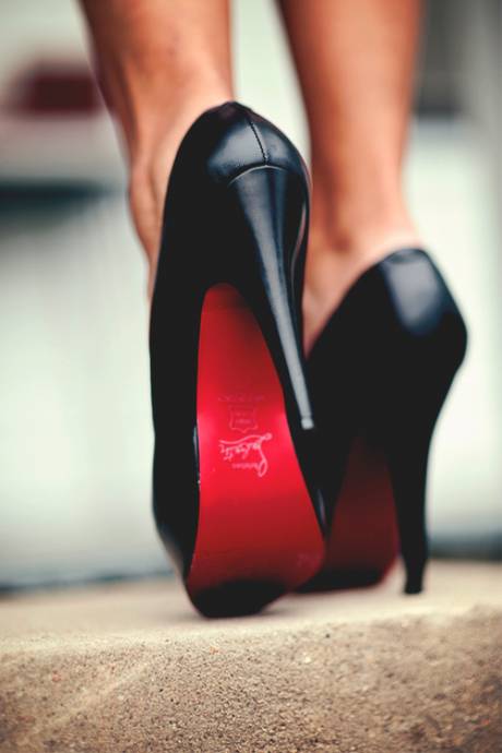 Ноги девушки в черных туфлях лабутенах
