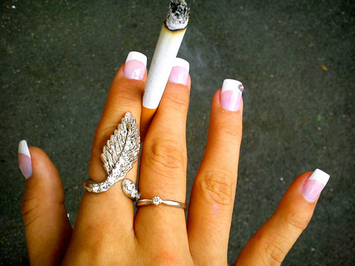 Сигарета в пальцах с французским маникюром