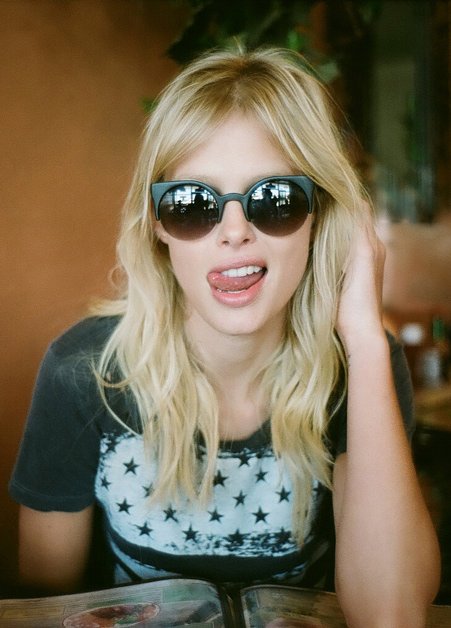 блондинка в солнечных очках облизывает губы